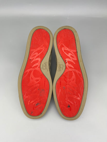 Red soles of shoes with a brand logo on a grey background