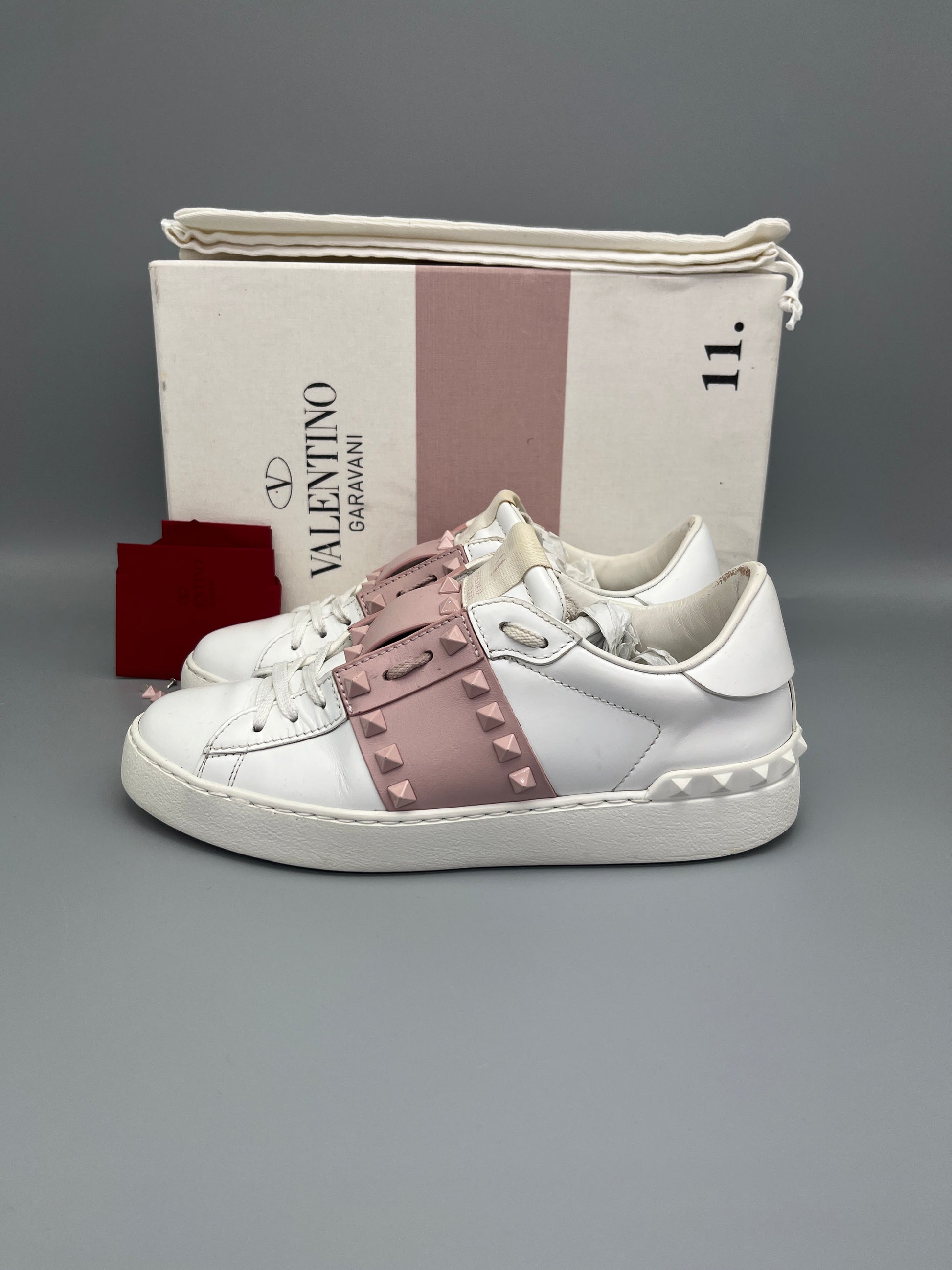 White sneaker with pink accents on a gray background